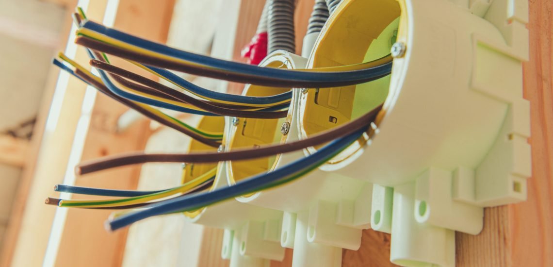 Three Electric Outlets Installation Inside Newly Developed House. Preparing Electric Wires For the Connection. Industrial Theme.